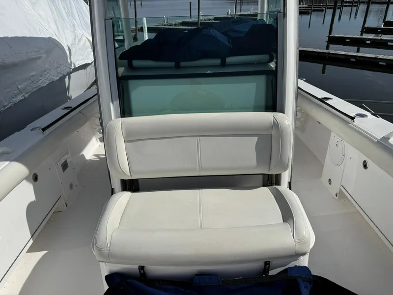 Slide: The Image of 2019 Everglades 273 CC boat interior with white seating and dock view. - 29