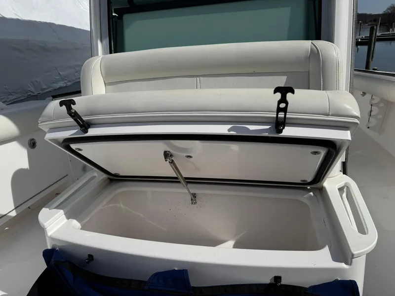 Slide: The Image of Open storage compartment on 2019 Everglades 273 CC boat with cushioned seating. - 30