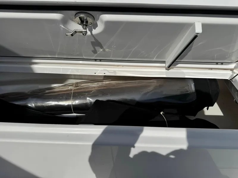 Slide: The Image of Storage compartment of a 2019 Everglades 273 CC boat, partially open with contents inside. - 32