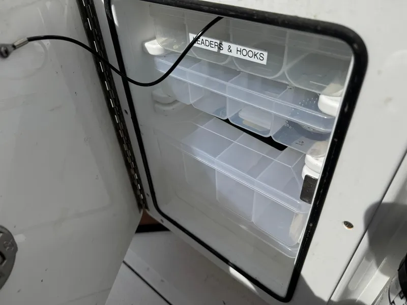 Slide: The Image of Storage compartment with labeled tackle boxes on Everglades 273 CC boat, 2019 model. - 37