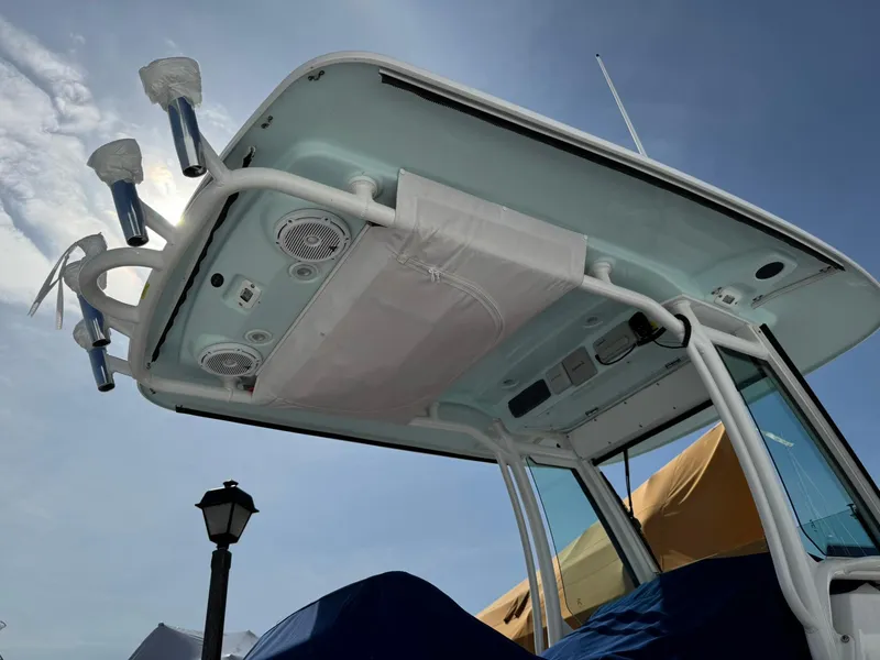 Slide: The Image of 2019 Everglades 273 CC boat, view of the overhead console and speakers under clear sky. - 39