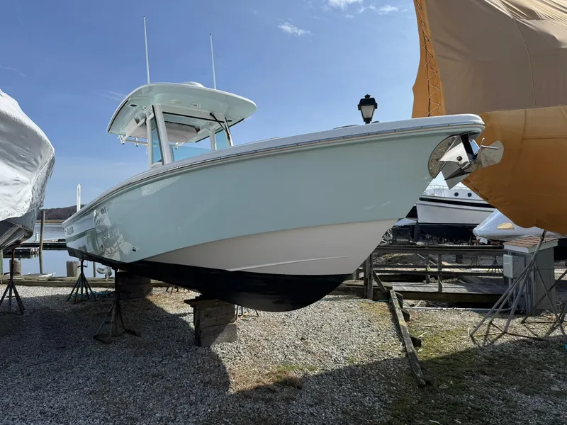 Slide: The Image of 2019 Everglades 273 CC boat on dry dock, under clear blue sky. - 40