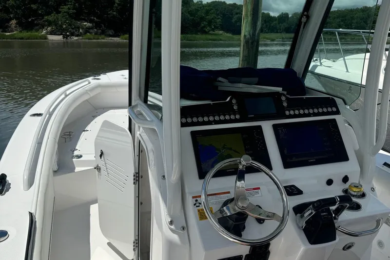 Slide: The Image of 2019 Everglades 273 Center Console boat interior with steering wheel and navigation screens. - 8
