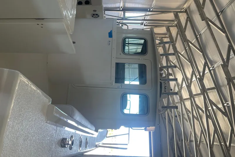 Slide: The Image of 2024 Parker 2320 Sport Cabin boat interior in a metal storage facility. - 10
