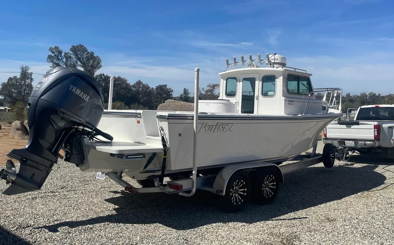 Slide: The Image of 2024 Parker 2320 Sport Cabin boat on trailer with Yamaha outboard motor. - 3