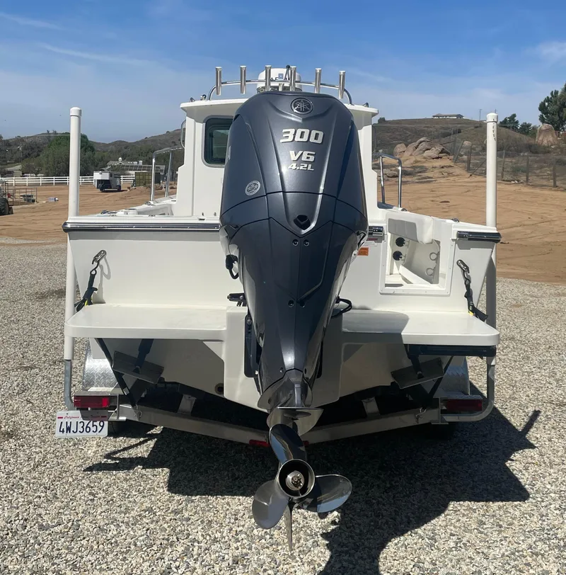Slide: The Image of 2024 Parker 2320 Sport Cabin boat with Yamaha 300 V6 engine, rear view. - 6