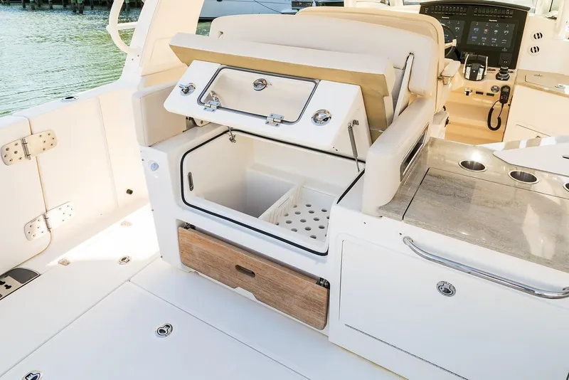 Slide: The Image of 2019 Boston Whaler 350 Realm interior with open storage compartment and sleek design. - 13