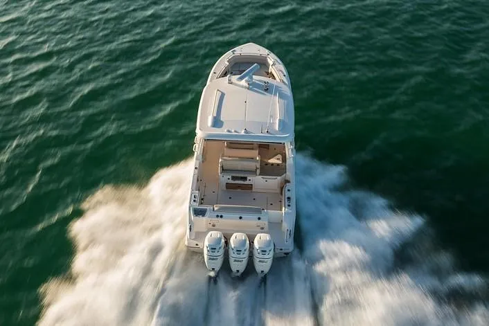 Slide: The Image of 2019 Boston Whaler 350 Realm cruising on open water, rear view. - 5