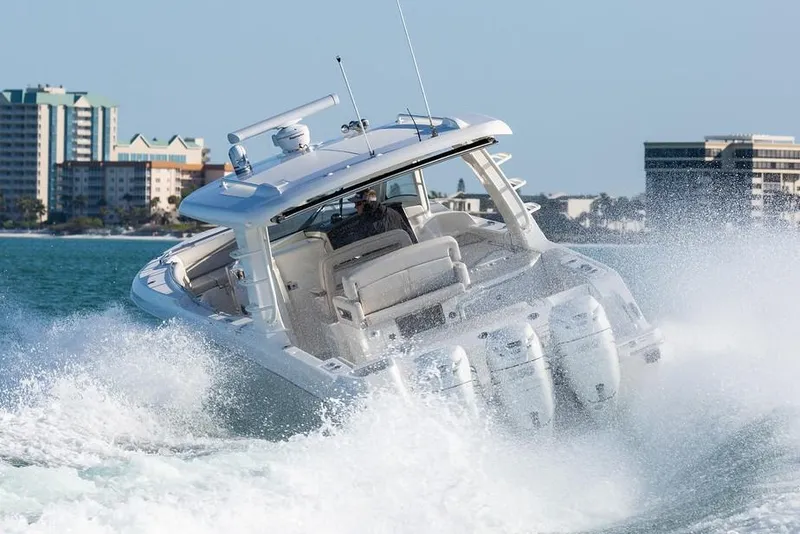 Slide: The Image of 2019 Boston Whaler 350 Realm cruising on ocean near city skyline. - 6