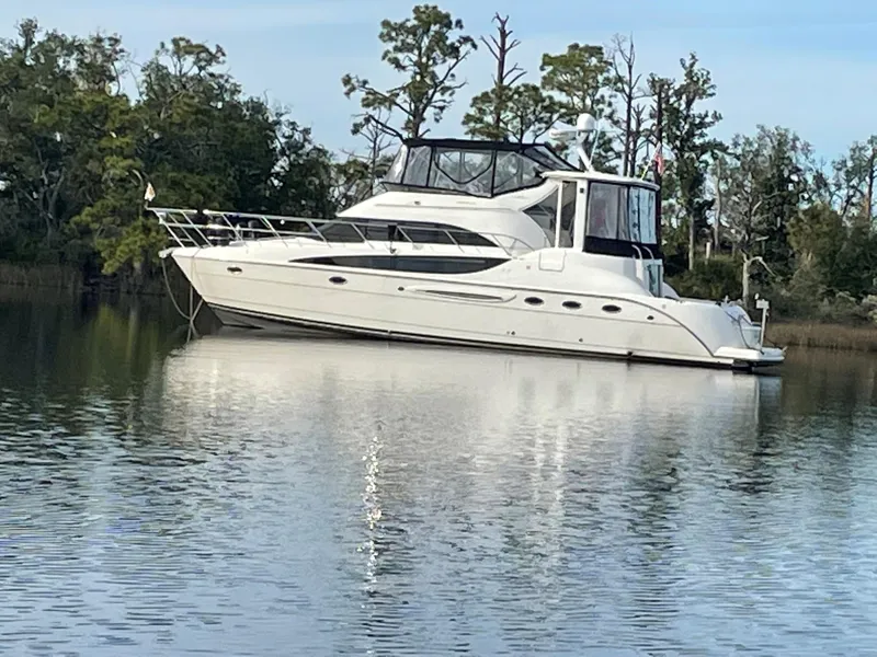 Slide: The Image of 2007 Meridian 459 Motoryacht on calm water, surrounded by trees. - 2