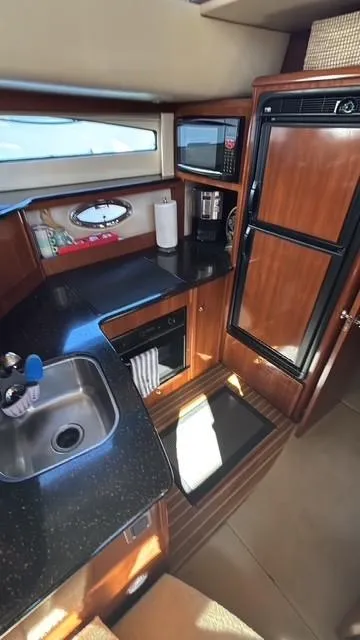 Slide: The Image of 2007 Meridian 459 Motoryacht kitchen with wood cabinetry, sink, and appliances. - 22