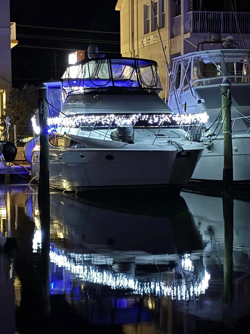 Slide: The Image of 2007 Meridian 459 Motoryacht adorned with festive lights, docked at night. - 40