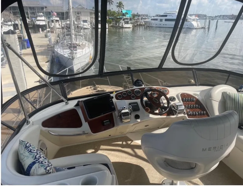 Slide: The Image of 2007 Meridian 459 Motoryacht helm with marina view, featuring modern controls and comfortable seating. - 7