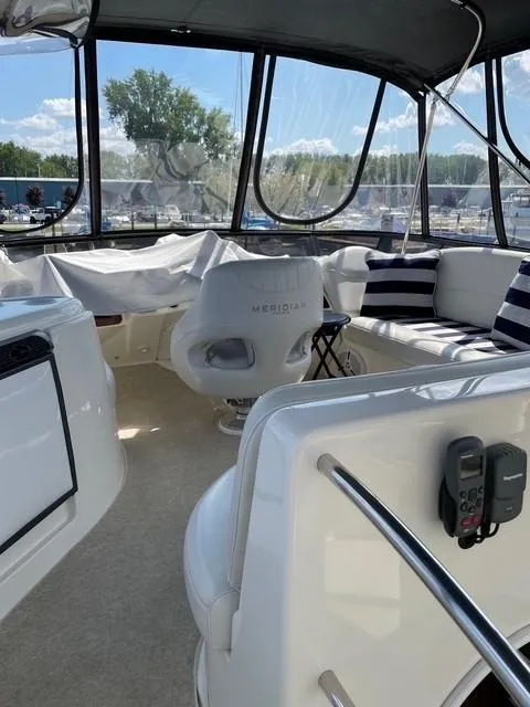 Slide: The Image of 2007 Meridian 459 Motoryacht interior with seating, helm chair, and panoramic windows. - 8