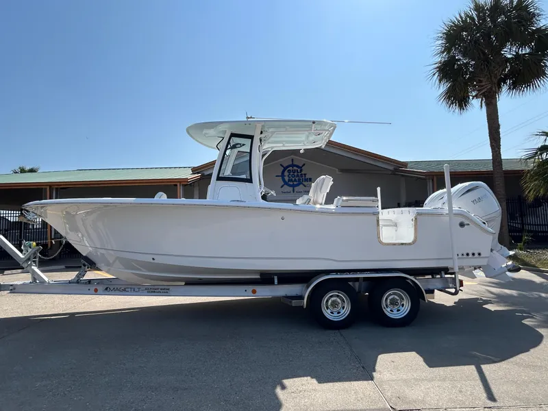 The Image of 2025 Sea Hunt Gamefish 25 boat on trailer, parked outdoors near a building and palm tree. - 1