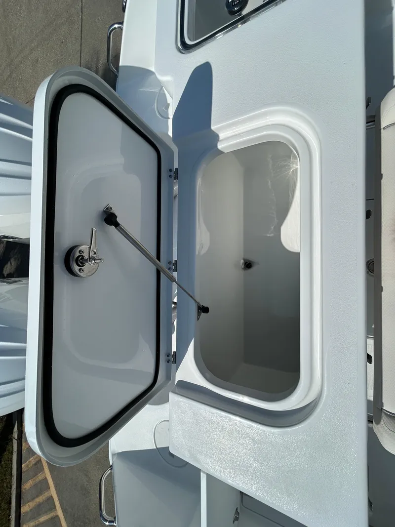 Slide: The Image of 2025 Sea Hunt Gamefish 25 boat storage compartment with open lid. - 10