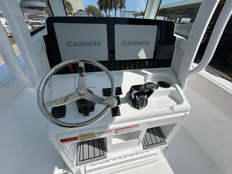 Slide: The Image of 2025 Sea Hunt Gamefish 25 helm with dual Garmin displays and steering wheel. - 18