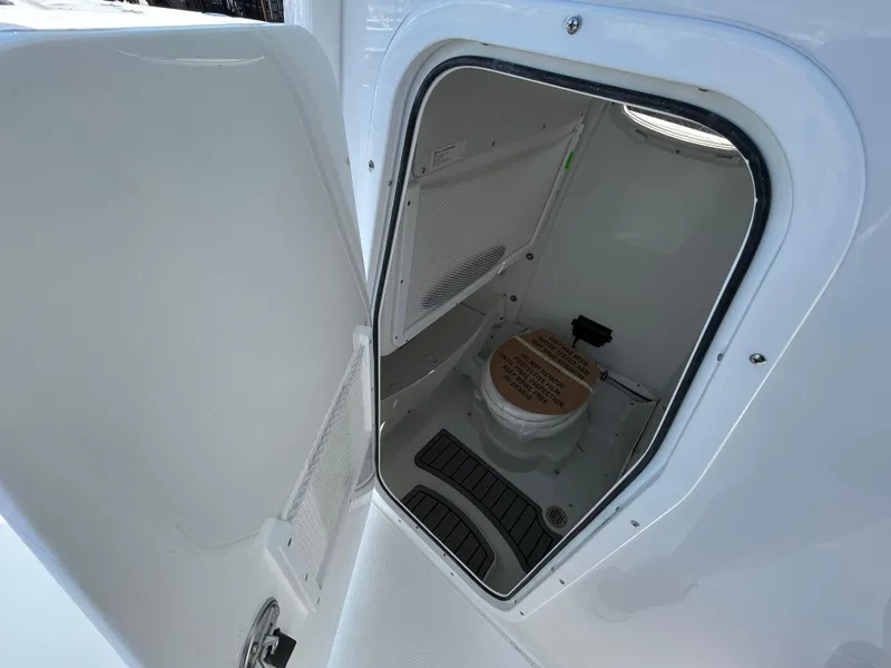 Slide: The Image of 2025 Sea Hunt Gamefish 25 boat interior with open door revealing compact marine toilet. - 20