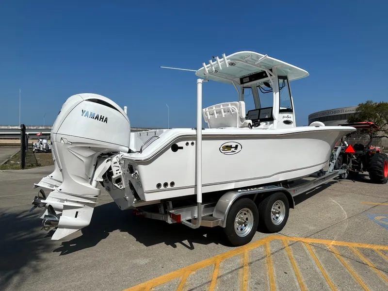 Slide: The Image of 2025 Sea Hunt Gamefish 25 boat on trailer with Yamaha engines, parked outdoors. - 3