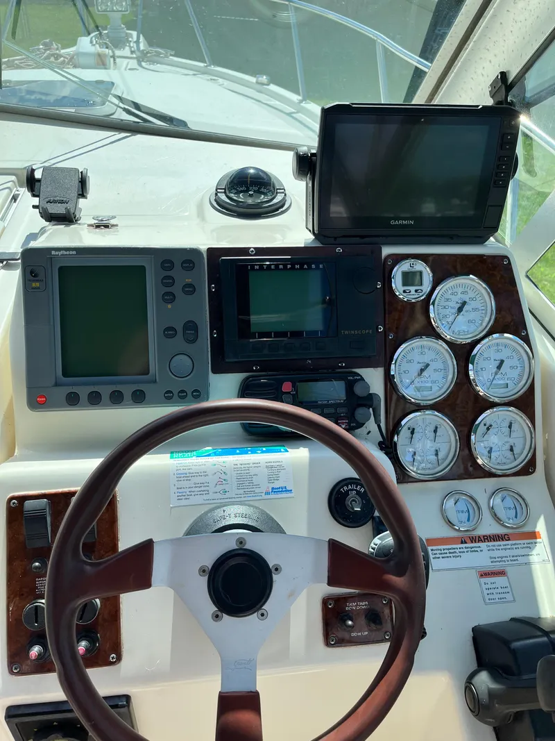 Slide: The Image of 2000 Pursuit 2860 Denali boat dashboard with steering wheel, gauges, and navigation equipment. - 11