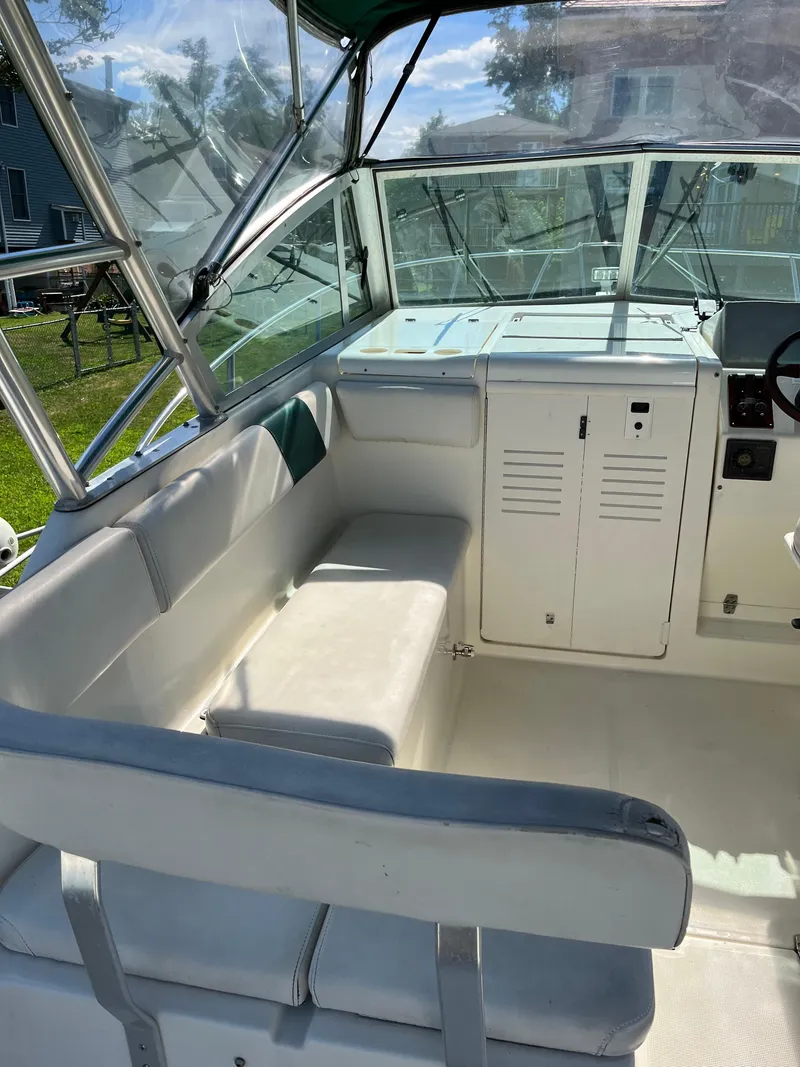 Slide: The Image of 2000 Pursuit 2860 Denali boat interior with white seating and control panel. - 15