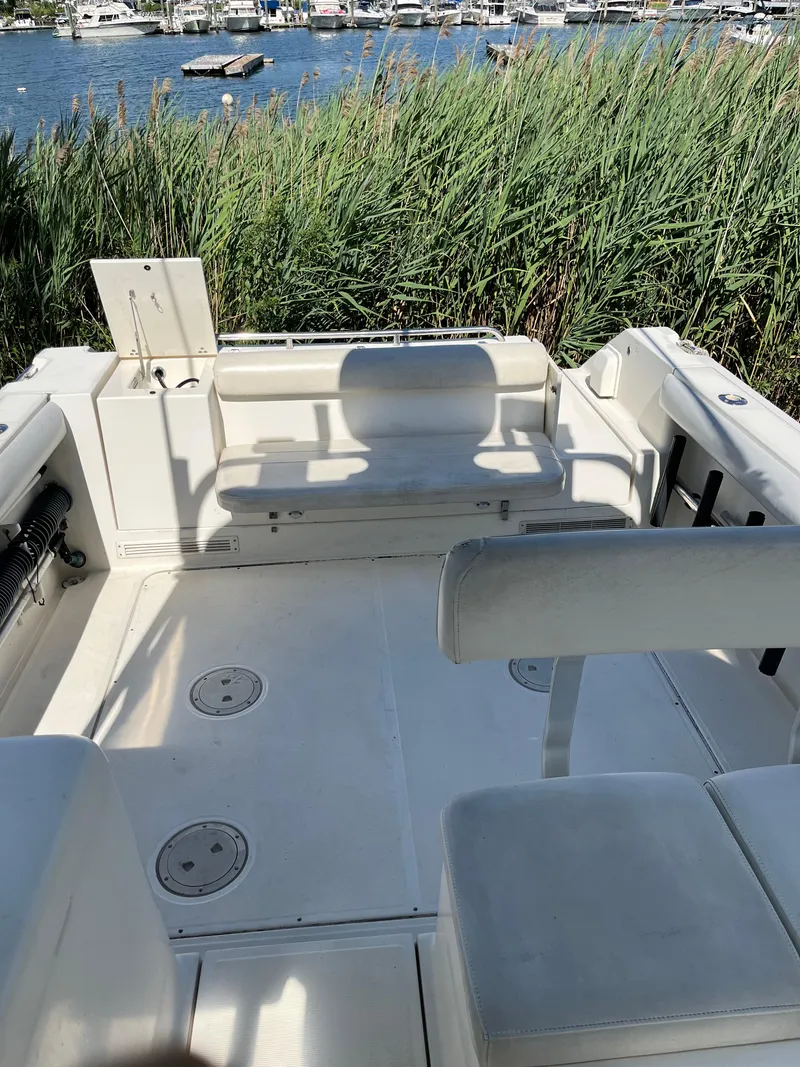 Slide: The Image of 2000 Pursuit 2860 Denali boat interior with seating, near water and reeds. - 16