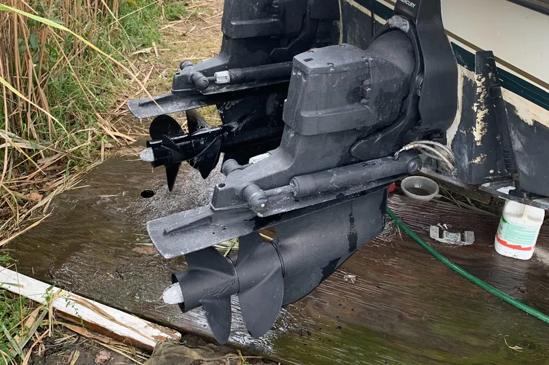 Slide: The Image of Twin outboard motors on a 2000 Pursuit 2860 Denali boat, resting on a wooden platform. - 23