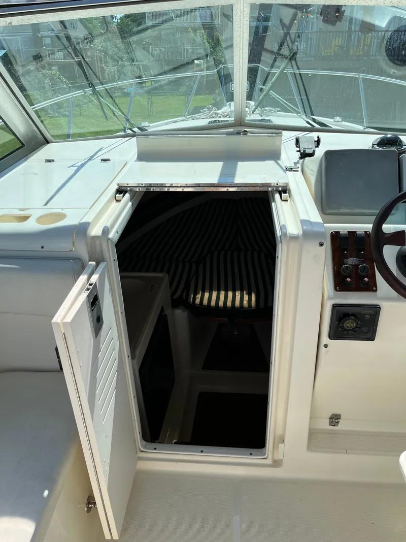 Slide: The Image of 2000 Pursuit 2860 Denali boat interior with open cabin door and steering wheel. - 4