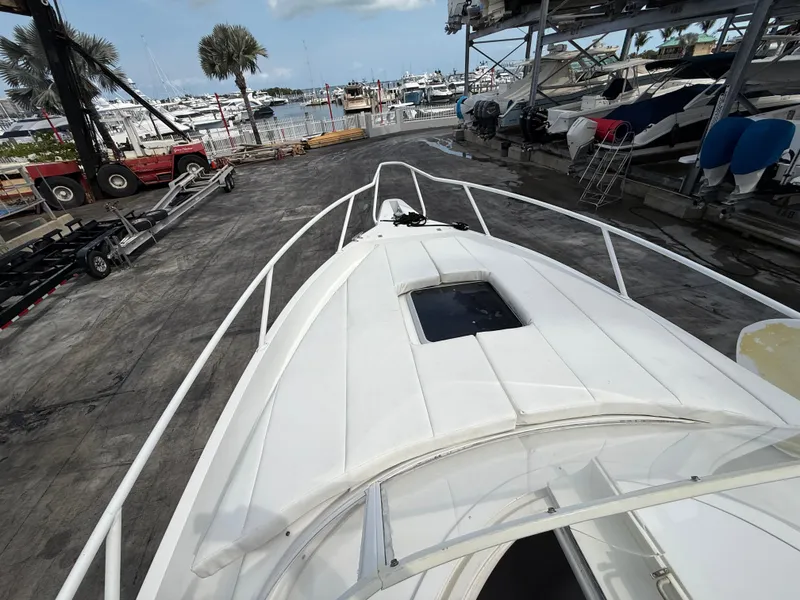 Slide: The Image of 1999 Intrepid 339 Walkaround boat docked, featuring spacious deck and marina view. - 10
