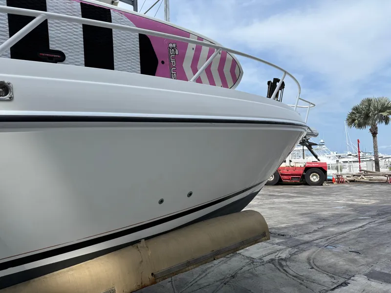 Slide: The Image of 1999 Intrepid 339 Walkaround boat docked, featuring sleek design and vibrant paddleboard. - 3