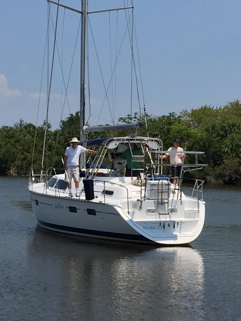 Slide: The Image of Sailboat "Hunter Passage 42" from 1993 on calm water with two people aboard. - 1
