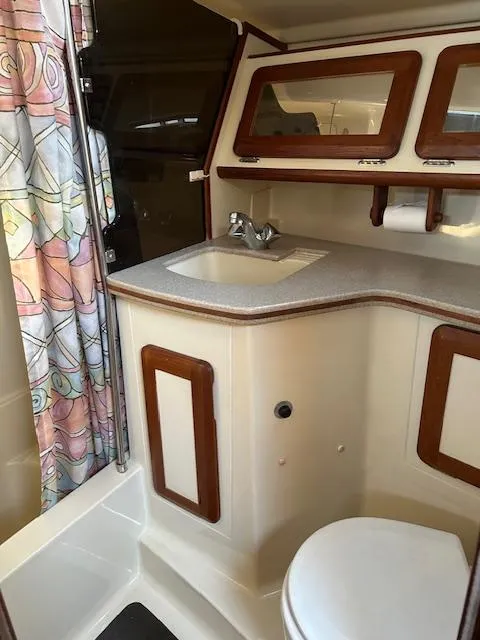 Slide: The Image of 1993 Hunter Passage 42 yacht bathroom with sink, toilet, and colorful shower curtain. - 12