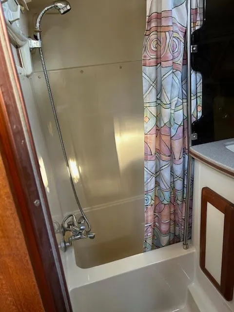 Slide: The Image of Shower area in 1993 Hunter Passage 42 sailboat with colorful curtain and compact design. - 13
