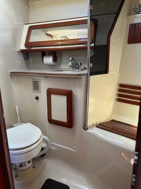 Slide: The Image of 1993 Hunter Passage 42 yacht bathroom with toilet, sink, and wooden accents. - 14