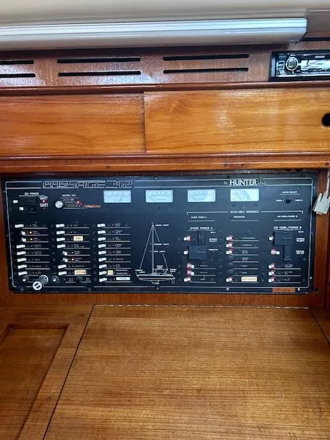 Slide: The Image of Control panel of a 1993 Hunter Passage 42 sailboat, featuring various switches and indicators. - 16