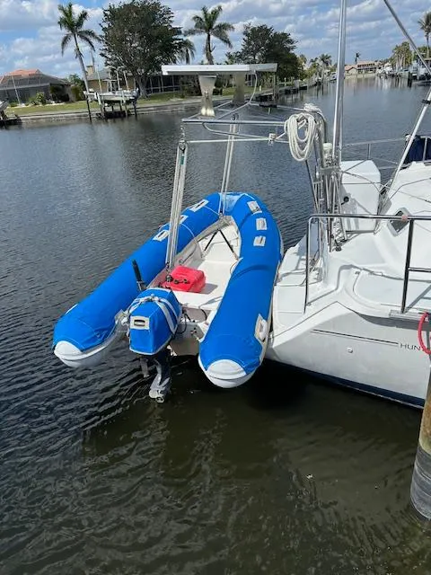 Slide: The Image of Hunter Passage 42 sailboat with blue inflatable dinghy, docked in a calm canal. - 19