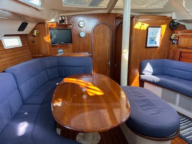 Slide: The Image of Interior of 1993 Hunter Passage 42 yacht with wooden furnishings and blue seating. - 2