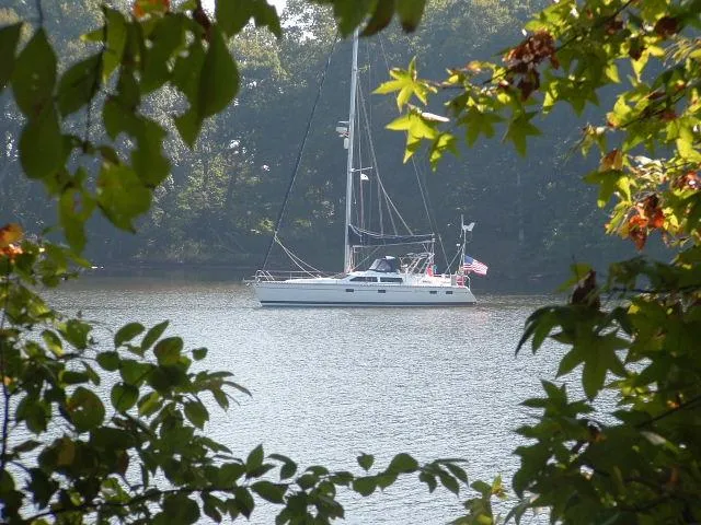 Slide: The Image of Sailboat Hunter Passage 42 (1993) on a serene lake, framed by lush green foliage. - 20
