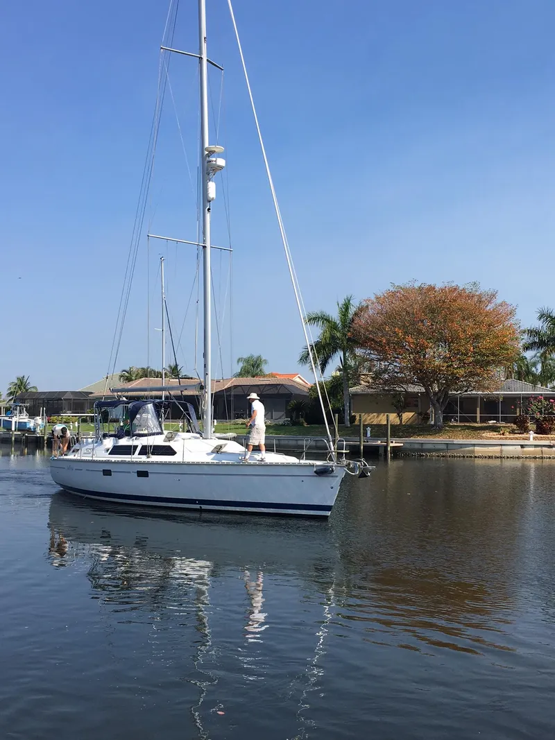 Slide: The Image of Sailboat Hunter Passage 42, 1993 model, cruising on a calm waterway with palm trees. - 21