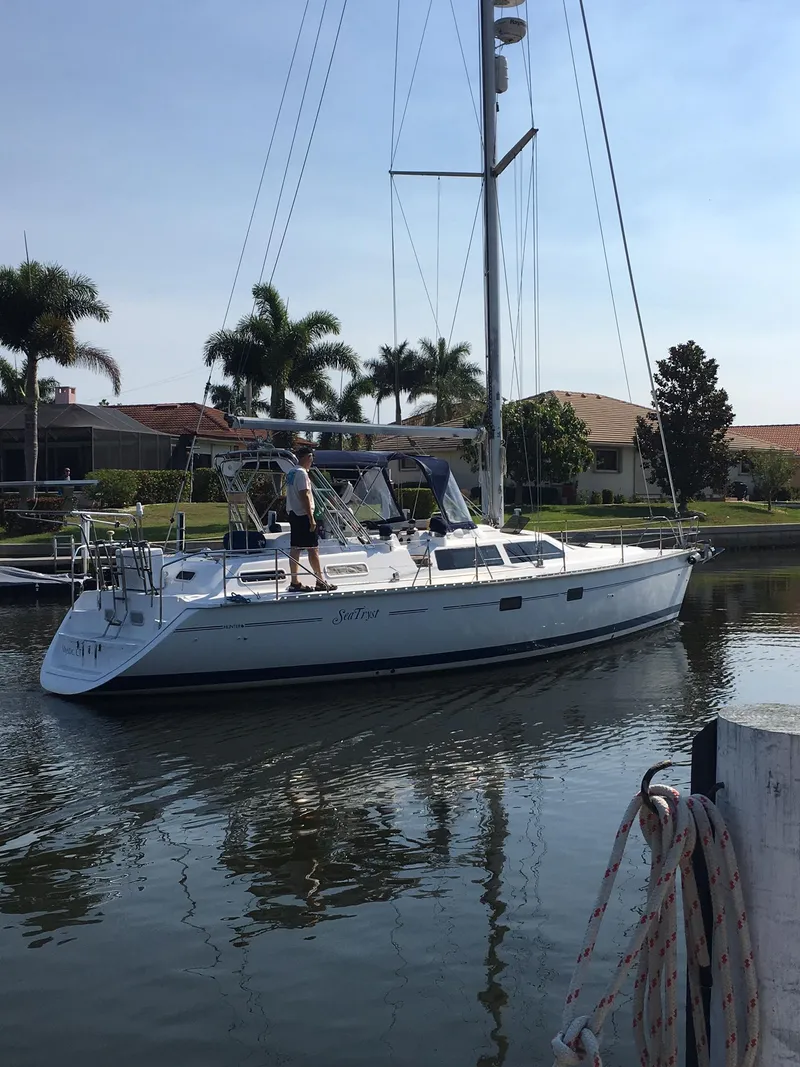 Slide: The Image of Sailboat Hunter Passage 42 (1993) docked in a sunny marina with palm trees. - 22