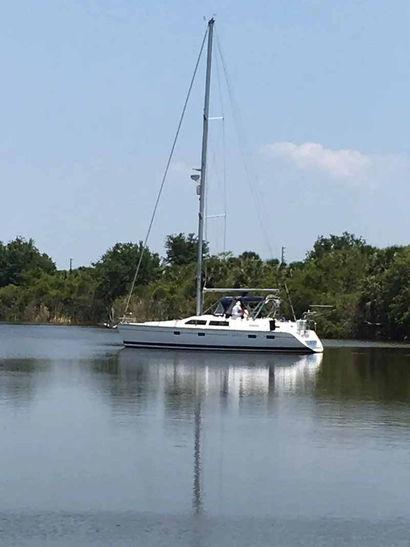 Slide: The Image of Sailboat on calm water, 1993 Hunter Passage 42, surrounded by greenery. - 23