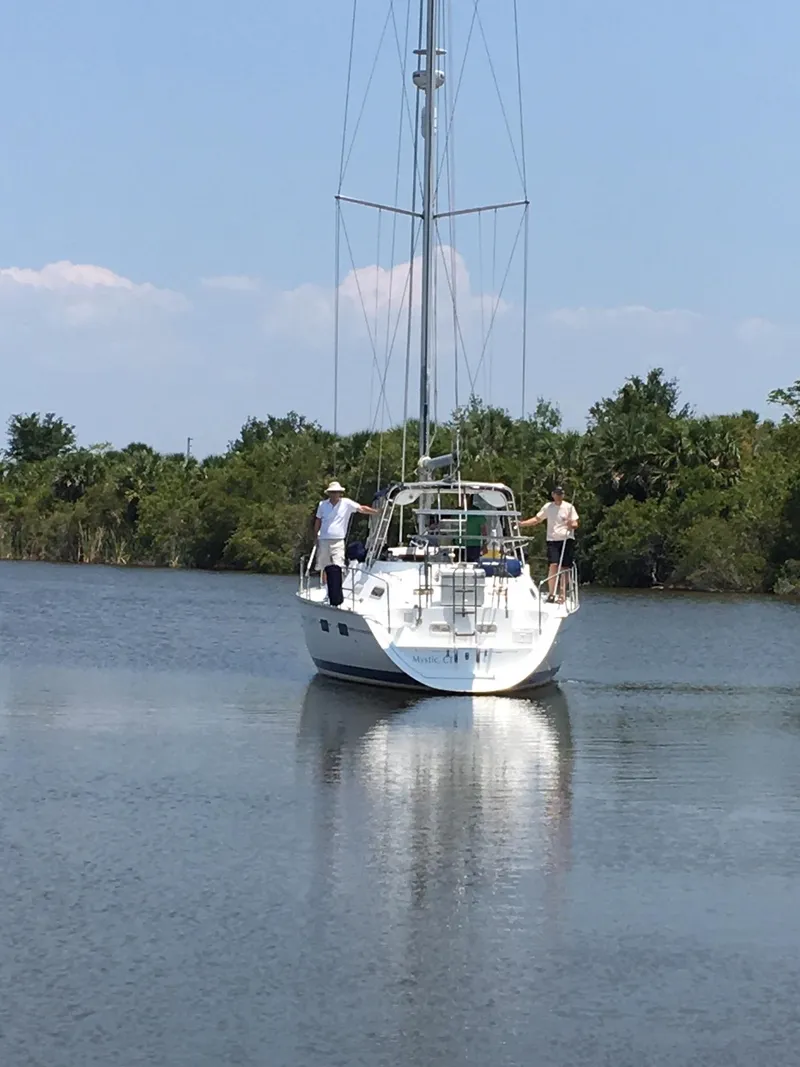 Slide: The Image of Sailboat Hunter Passage 42 (1993) on calm water with two people aboard. - 24