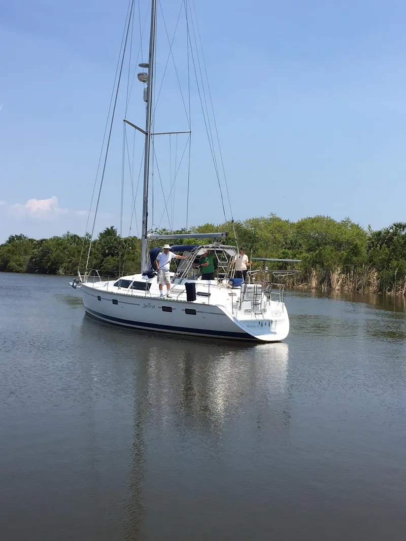 Slide: The Image of Sailboat Hunter Passage 42, 1993 model, cruising on a calm river with lush greenery. - 25