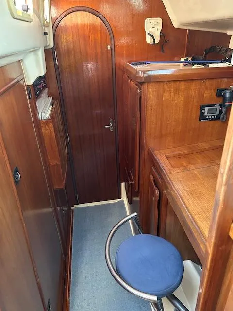 Slide: The Image of Interior of 1993 Hunter Passage 42 sailboat with wooden cabinetry and blue cushioned stool. - 5