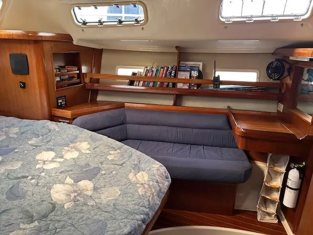 Slide: The Image of Cozy interior of 1993 Hunter Passage 42 sailboat with bookshelves and seating area. - 9
