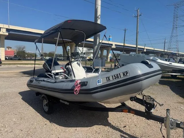 Slide: The Image of 2019 Zodiac Bayrunner 420 inflatable boat with Yamaha outboard motor, parked on a trailer. - 4