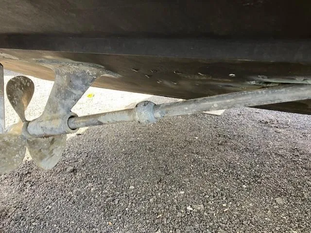 Slide: The Image of Propeller and shaft of 1987 Blackfin 32 Flybridge boat on gravel surface. - 10