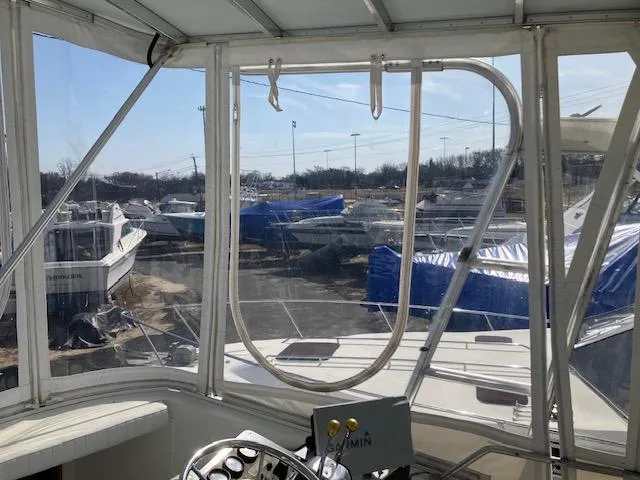 Slide: The Image of 1987 Blackfin 32 Flybridge interior view with marina and boats in the background. - 12