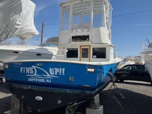 Slide: The Image of 1987 Blackfin 32 Flybridge boat with "Fins Up!!" text, Deptford, NJ, in a marina. - 4