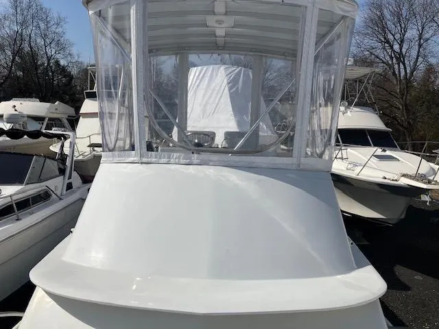 Slide: The Image of 1987 Blackfin 32 Flybridge boat with enclosed flybridge, docked among other vessels. - 7